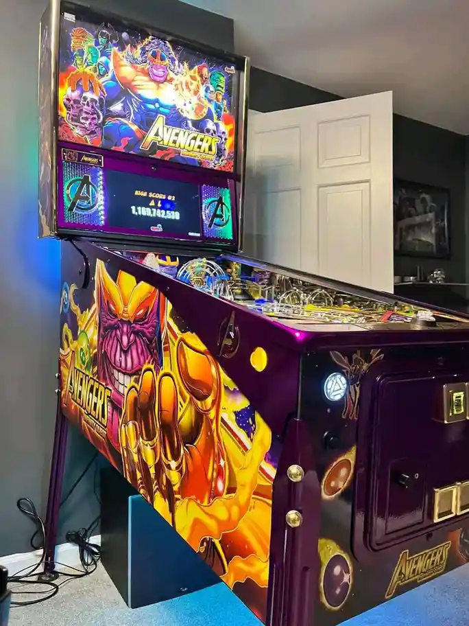 A brightly lit Avengers: Infinity Quest pinball machine with a high score of 1,169,742,530 displayed on its screen…