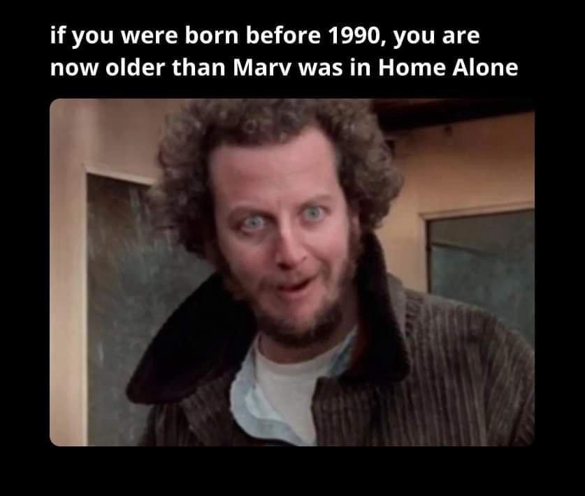A close-up image of Marv from the movie Home Alone, showing his wide-eyed, surprised facial expression. He has curly brown…