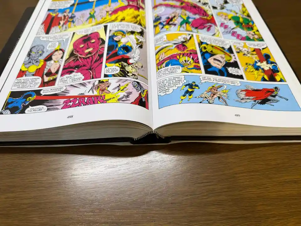 An open comic book on pages 488 and 489 shows a battle scene with characters like Colossus and Nightcrawler. The text bubble…