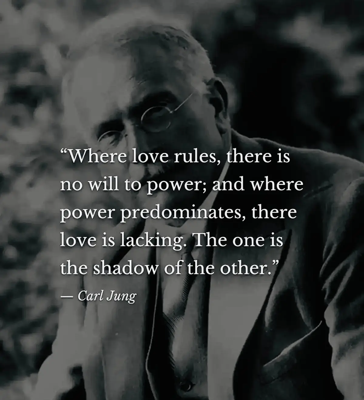 A black-and-white photo of Carl Jung, an older man with glasses and a mustache, wearing a suit and tie, looking thoughtfully…