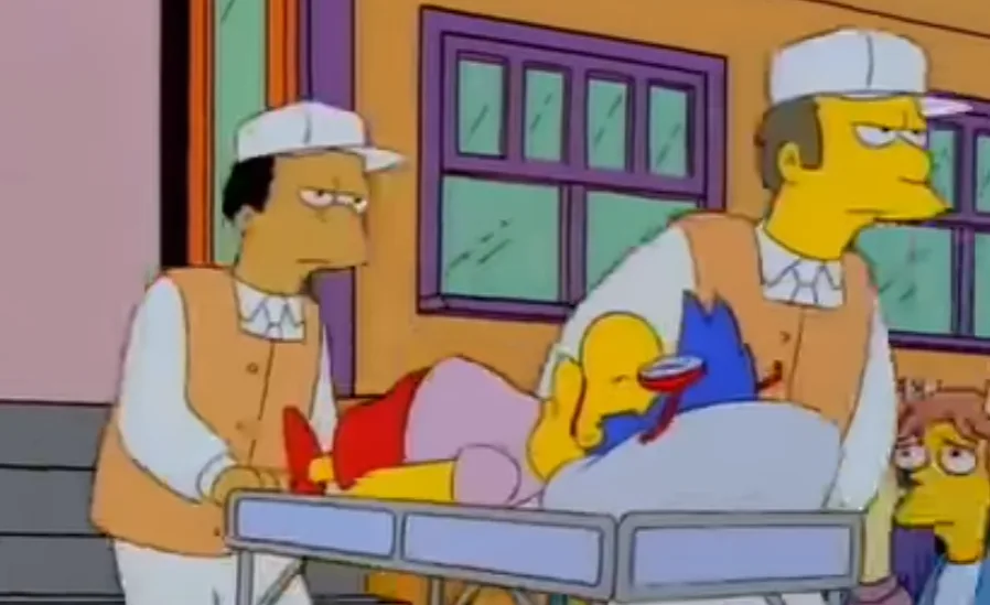 This image from The Simpsons shows Bart Simpson lying on a hospital gurney, covered in blood and holding a glass of red…