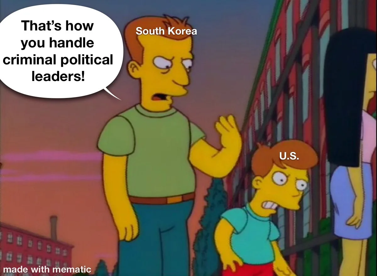 A still from The Simpsons shows a tall man labeled 'South Korea' gesturing confidently while speaking, with a speech bubble…
