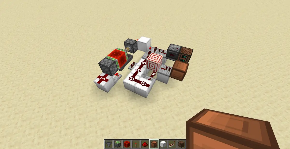 A Minecraft redstone contraption built on sand, featuring a clock mechanism with redstone dust, repeaters, and a digital…