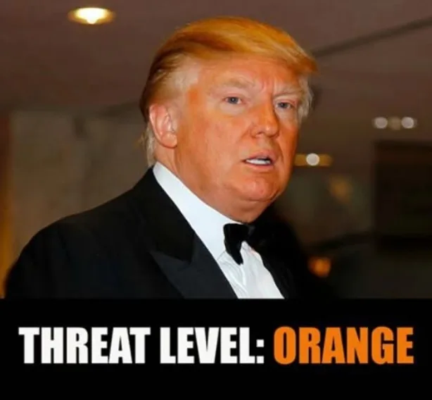 A man with blond hair wearing a black tuxedo and bow tie looks surprised or concerned. A black banner at the bottom of the…