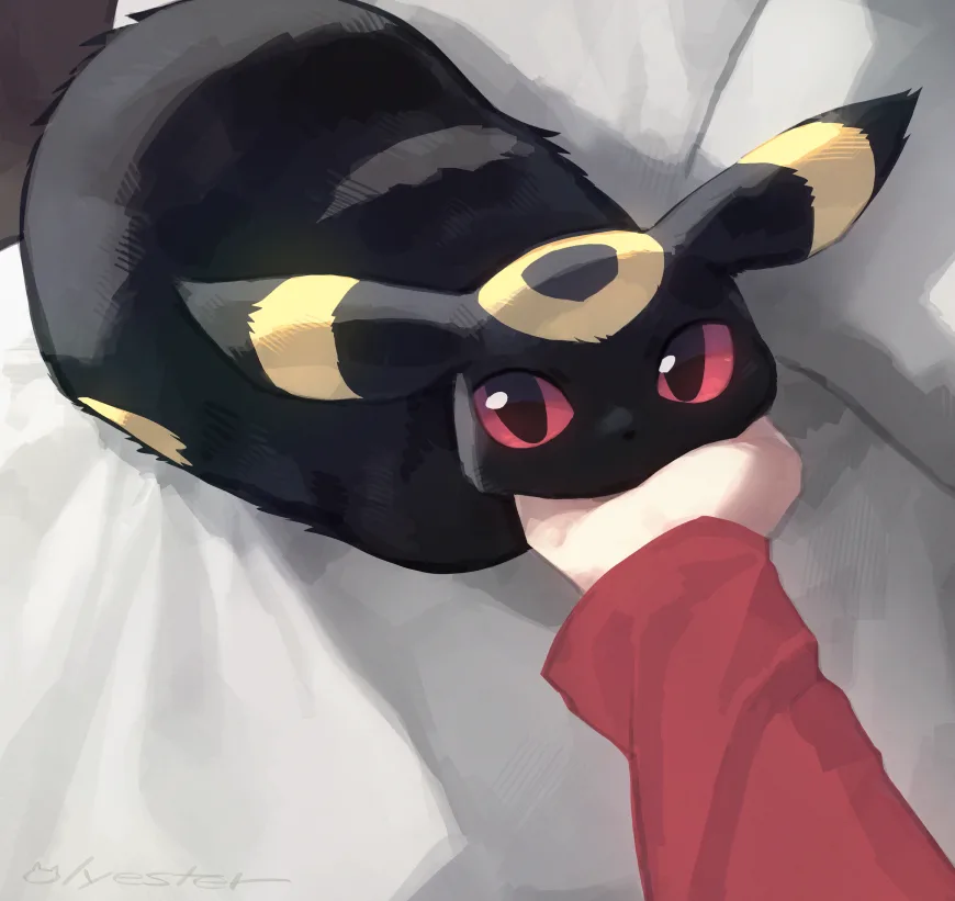 A black, cat-like creature with yellow-tipped ears and red eyes is curled up and being held by a person wearing a red…