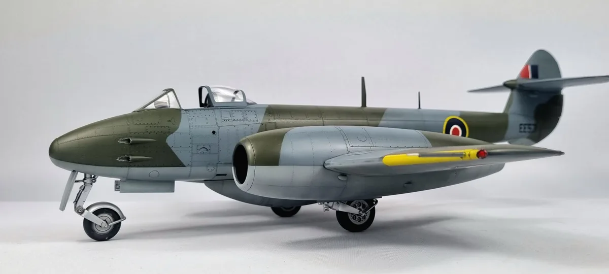 A highly detailed scale model of a British jet fighter aircraft, likely a Gloster Meteor, is shown in profile against a…