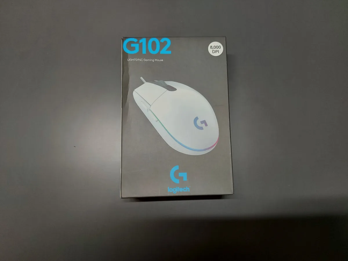 A Logitech G102 LIGHTSYNC Gaming Mouse box is shown, featuring a white mouse with RGB lighting and '8,000 DPI' highlighted…