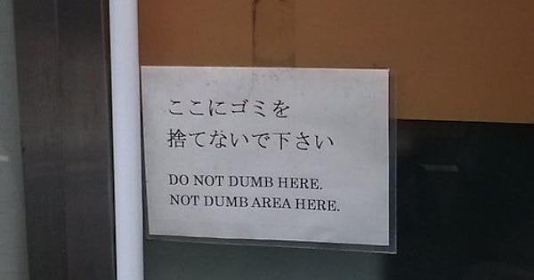 A white sign on a glass door has Japanese text at the top reading 'ここにゴミを捨てないで下さい' (Please do not litter here) and below it…