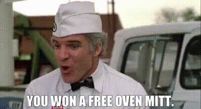 A man in a white chef's uniform and hat, with a surprised or shocked facial expression, is shown outdoors near a white van…