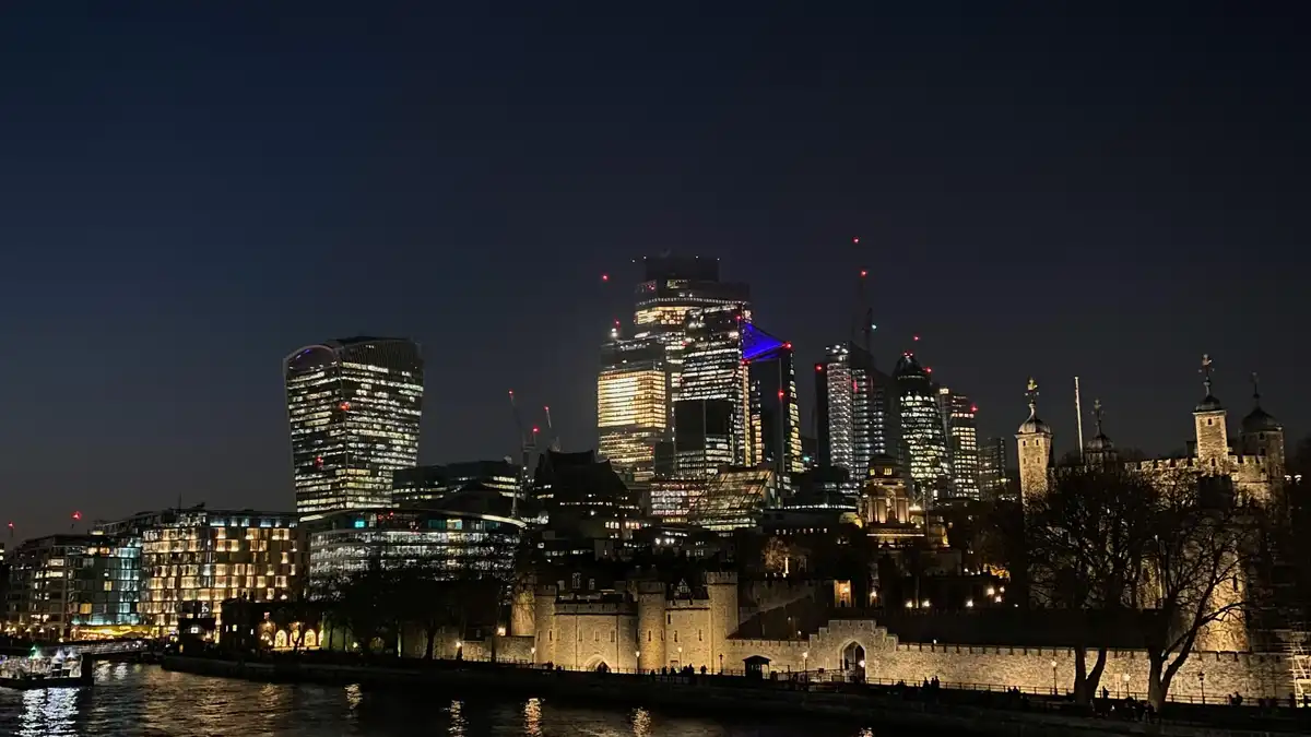 Twinkling lights dance across the steel skyscrapers as night descends on London's iconic skyline. The Thames River glimmers…