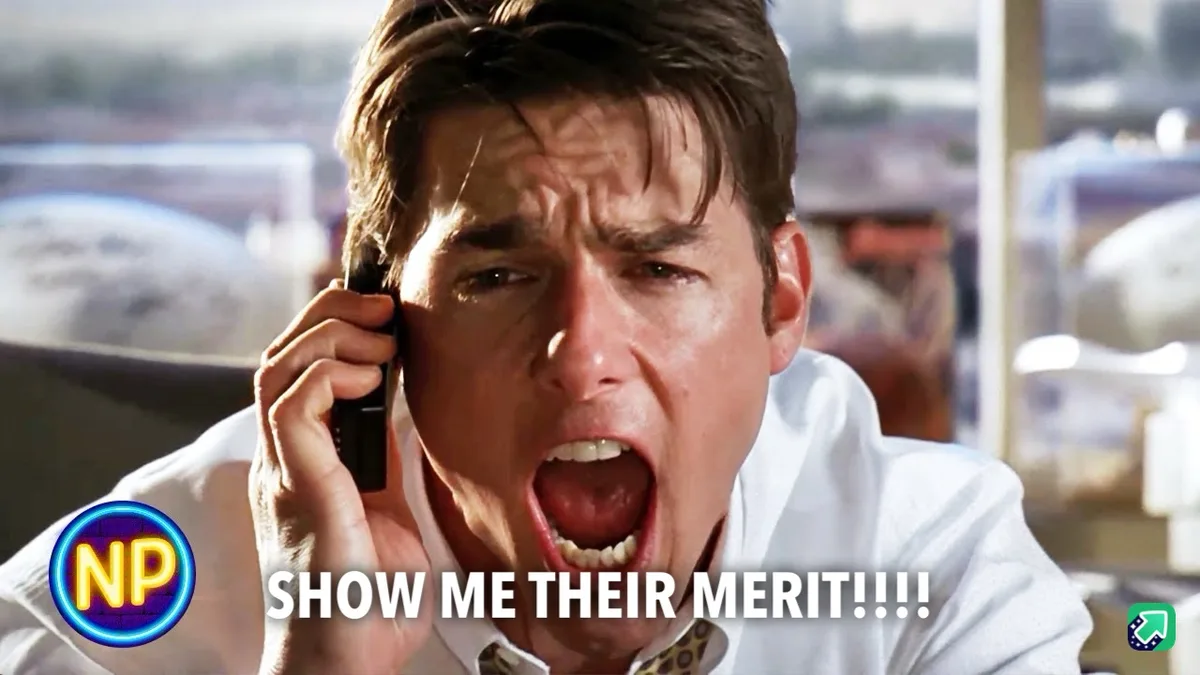 A close-up of actor Tom Cruise in a white shirt, yelling into a black phone with an intense, frustrated expression. The…