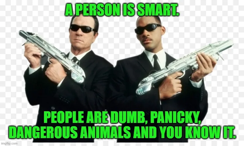 Two men in black suits and sunglasses, holding silver guns, stand side by side against a checkered background. Green text at…