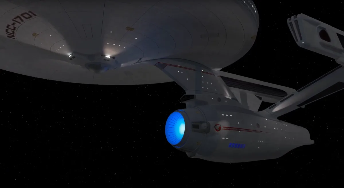 A Star Trek Enterprise NCC-1701 spaceship is shown in space with its blue warp core glowing. The ship's saucer section and…