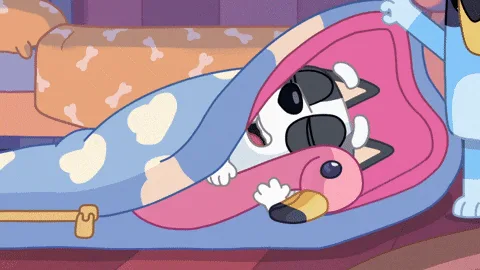 A cartoon dog is shown in six panels, each depicting the same scene: the dog is lying in bed under a blue blanket with white…