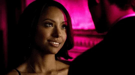 A six-panel image shows a woman in a dimly lit, pink-hued setting, transitioning from a neutral expression to a smug…
