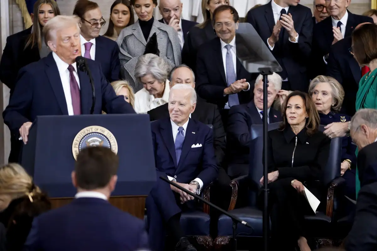 A photo shows Donald Trump speaking at a podium with the presidential seal, while Joe Biden sits in the audience with a…