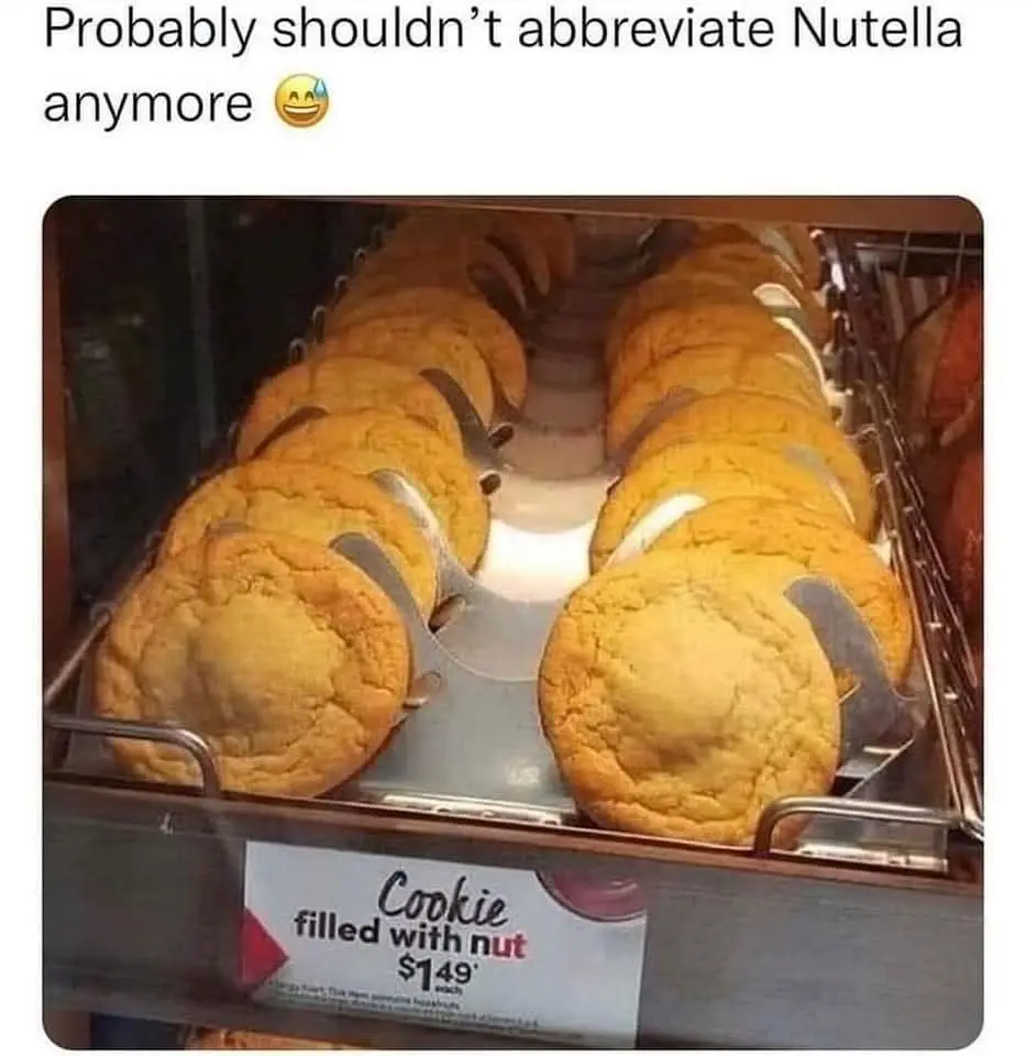 A display case filled with golden-brown cookies, each with a white filling, arranged in rows. A price tag below reads…