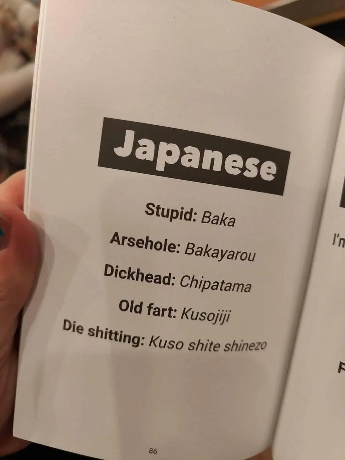 A close-up photo shows a hand holding an open book, displaying page 86 with a 'Japanese' heading. The page lists English…