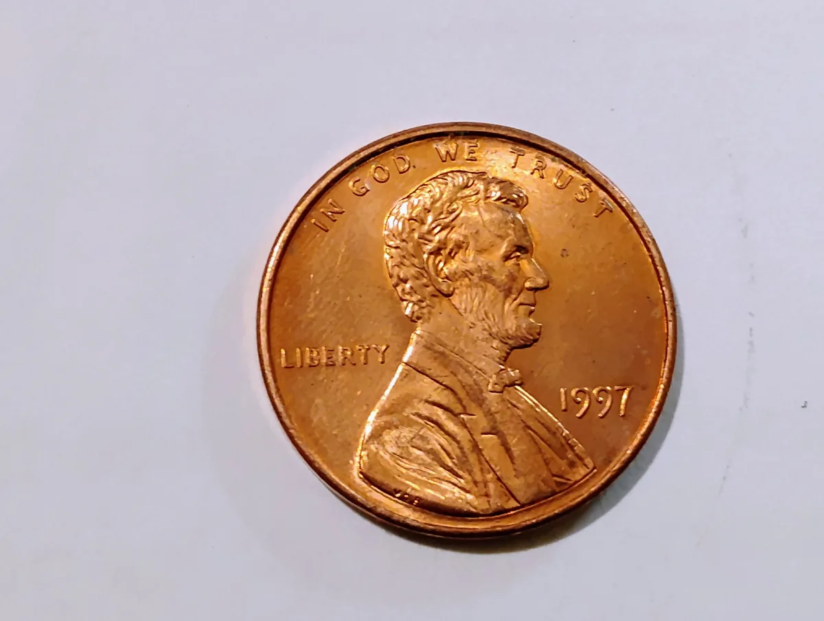 A close-up photo of a 1997 U.S. Lincoln penny, showing Abraham Lincoln's profile, the inscriptions 'IN GOD WE TRUST' along…