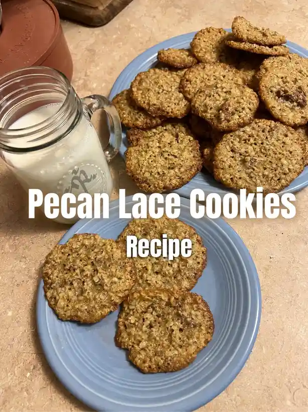 A photo shows two blue plates piled with thin, crumbly, golden-brown cookies containing visible pecan pieces, next to a…