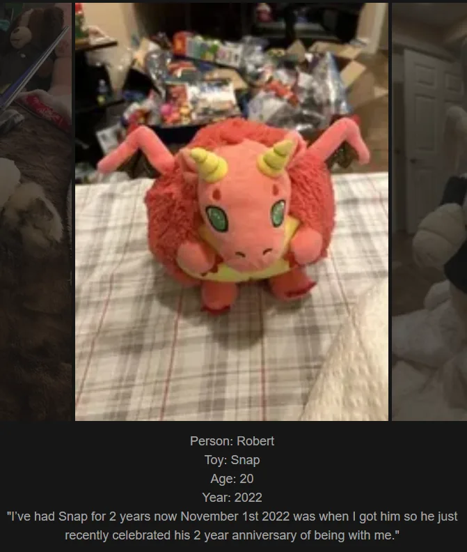 A pink, fluffy plush toy resembling a dragon or cow with horns and green eyes sits on a plaid blanket. Text overlaid at the…