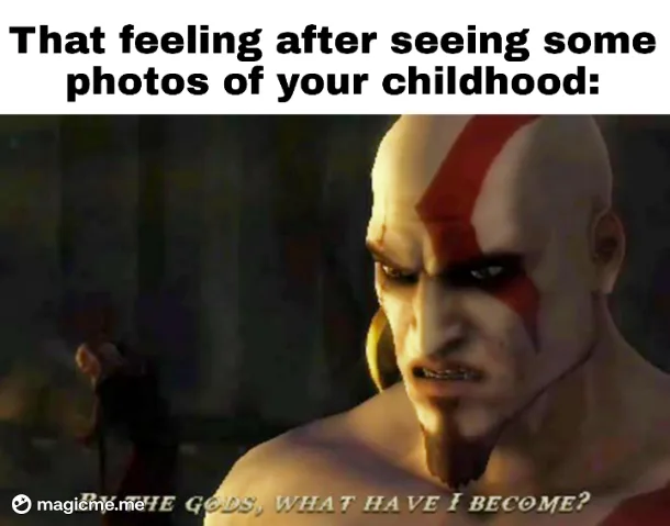A close-up of the video game character Kratos from God of War, showing his intense, horrified facial expression. He has his…