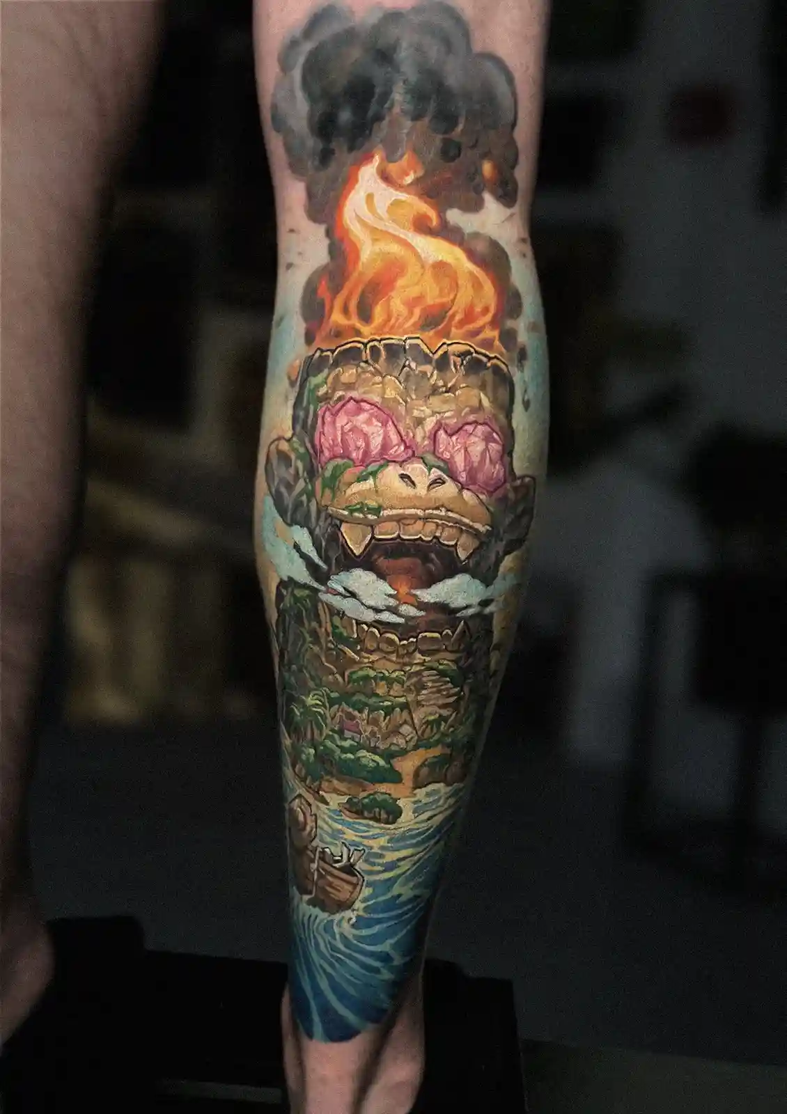 A person's forearm displays a detailed tattoo of a giant stone monkey head with pink sunglasses, erupting in flames and…