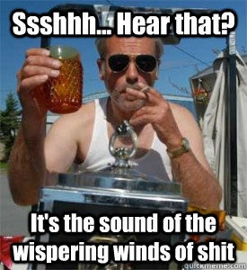 A man in a white tank top and sunglasses holds a glass of amber liquid in one hand and a cigarette in the other, standing…