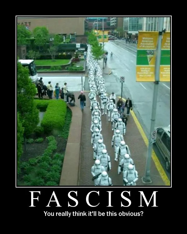 An overhead photo shows a long line of people dressed as Star Wars stormtroopers marching in formation down a city sidewalk…