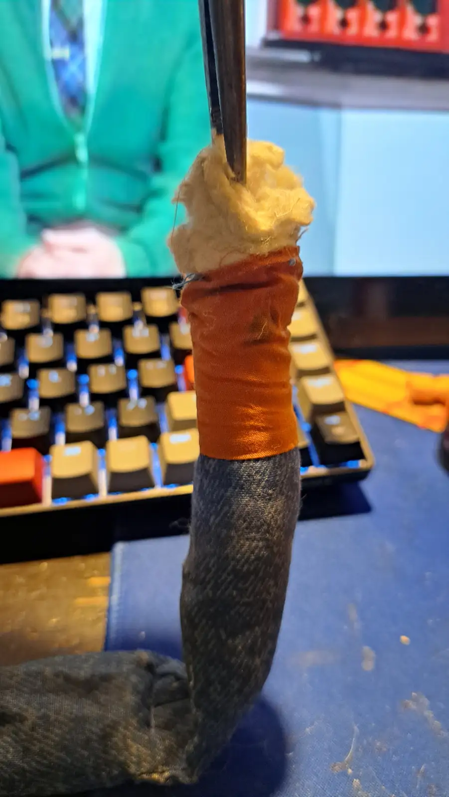 A close-up photo shows a person's sock-covered foot with an orange bandage and yellow stuffing protruding from the top, held…