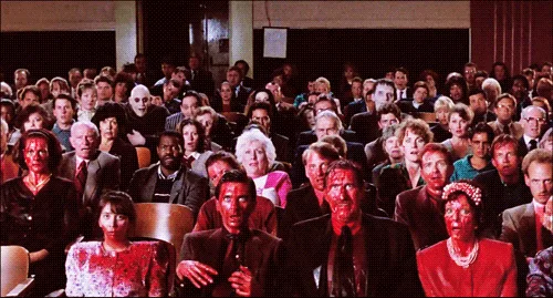 The image shows two identical horizontal panels of an audience in a theater. In the top panel, the audience is frozen in a…
