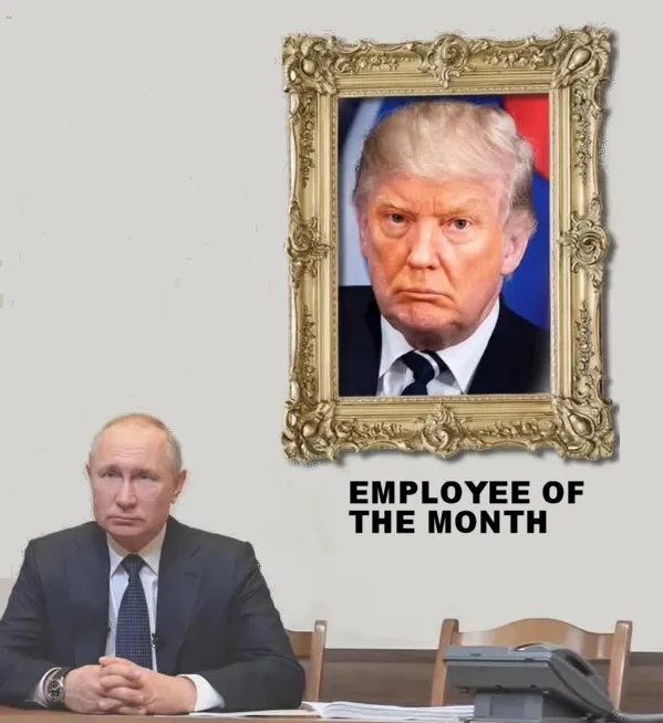 A man in a suit sits at a desk looking serious, with a framed portrait of Donald Trump hanging on the wall behind him. Below…
