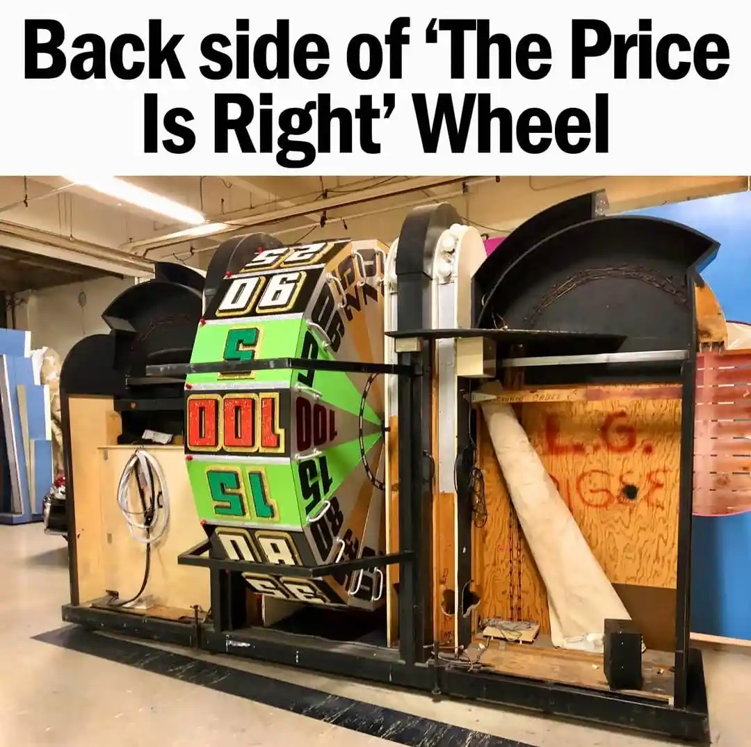 The image shows the back of a large, colorful game show wheel from 'The Price Is Right', revealing its internal mechanics…
