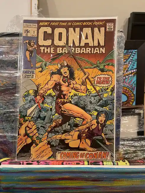 A vintage 1970s Marvel comic book cover for 'Conan the Barbarian' #1, featuring the titular character in a dynamic battle…