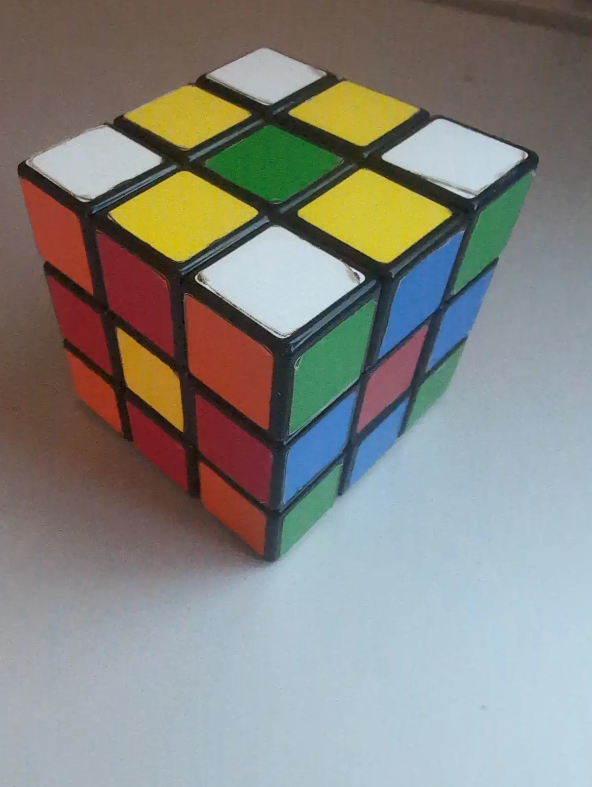 A solved Rubik's cube with its colorful faces visible, showing a completed state with each side having one solid color. The…