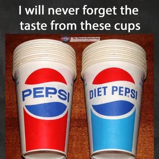 Two stacks of paper cups sit side by side on a wooden surface. The left stack is branded with the classic red, white, and…