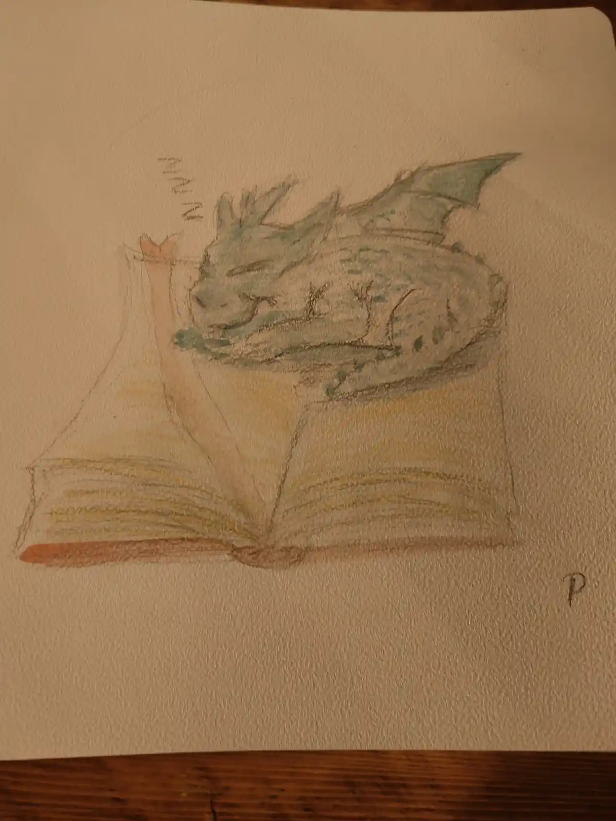 A hand-drawn illustration shows a small green dragon curled up and sleeping soundly on top of an open book, with 'zzzz'…