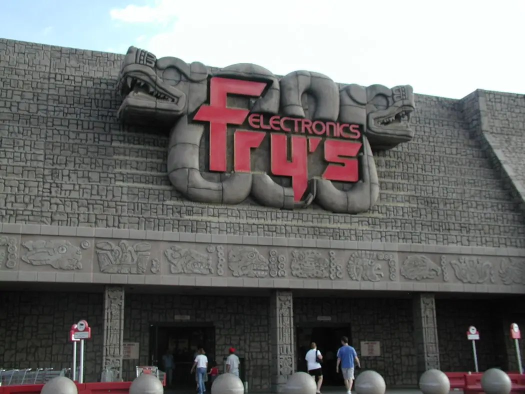 The exterior of a Fry's Electronics store features a large, red, stylized 'Fry's' logo with 'ELECTRONICS' in smaller text…