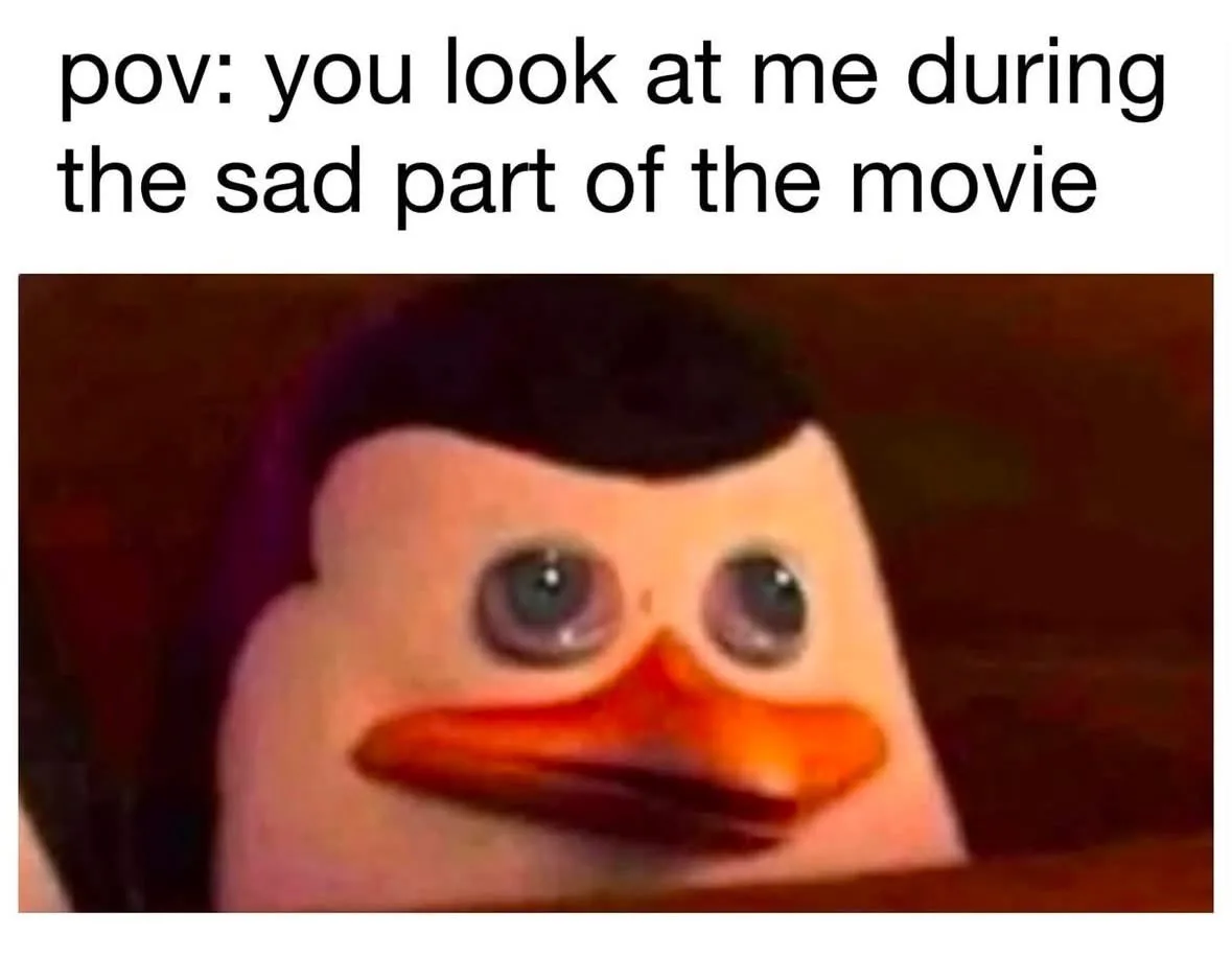 The image shows a close-up of a penguin-like character with large, teary eyes and a downturned beak, conveying a sad…