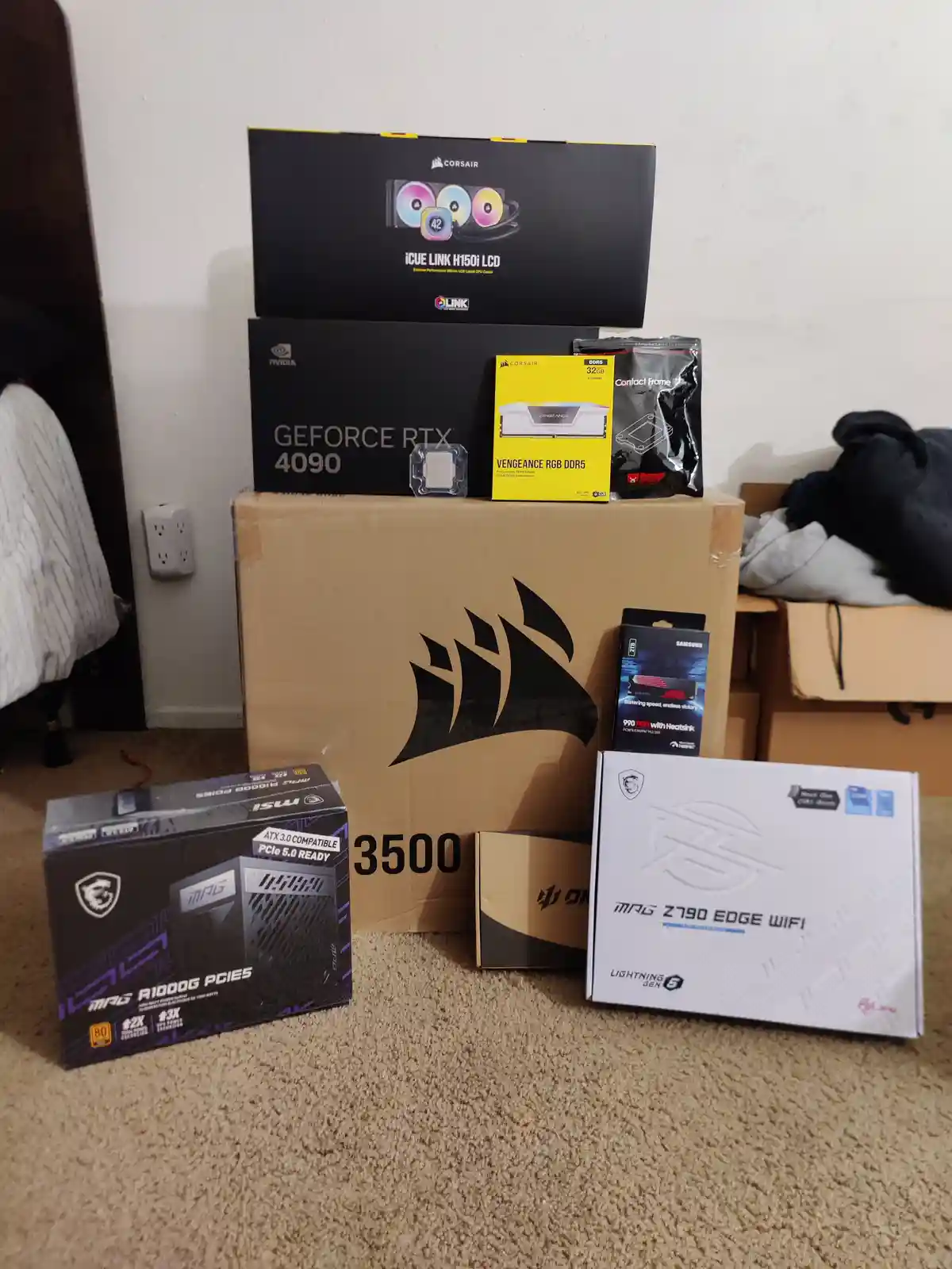 A pile of high-end computer hardware boxes, including an NVIDIA GeForce RTX 4090, Corsair iCUE LINK H150i LCD, Corsair…
