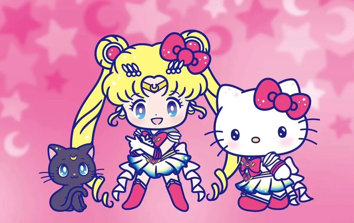 A chibi-style illustration shows Sailor Moon, her black cat Luna, and Hello Kitty all dressed in matching sailor fuku…