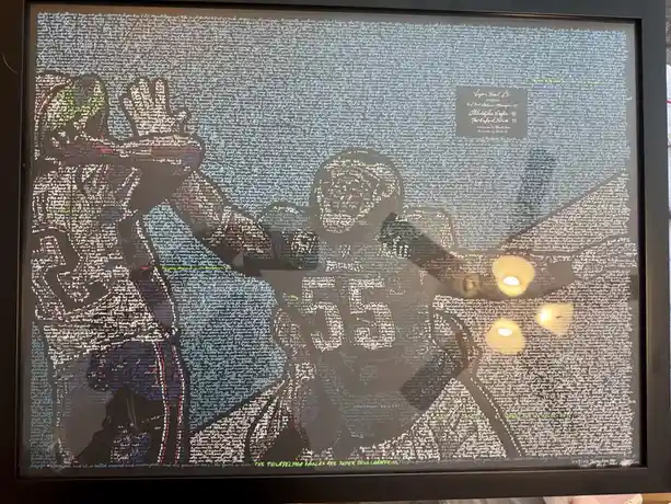 A framed artwork depicting two football players in celebratory poses, rendered as silhouettes formed from dense, colorful…