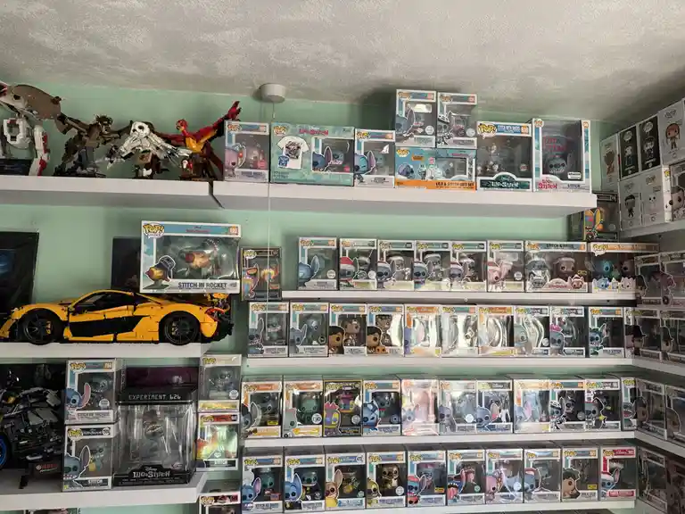A room filled with shelves displaying hundreds of Funko Pop! figures of Stitch from Lilo & Stitch, along with other Disney…