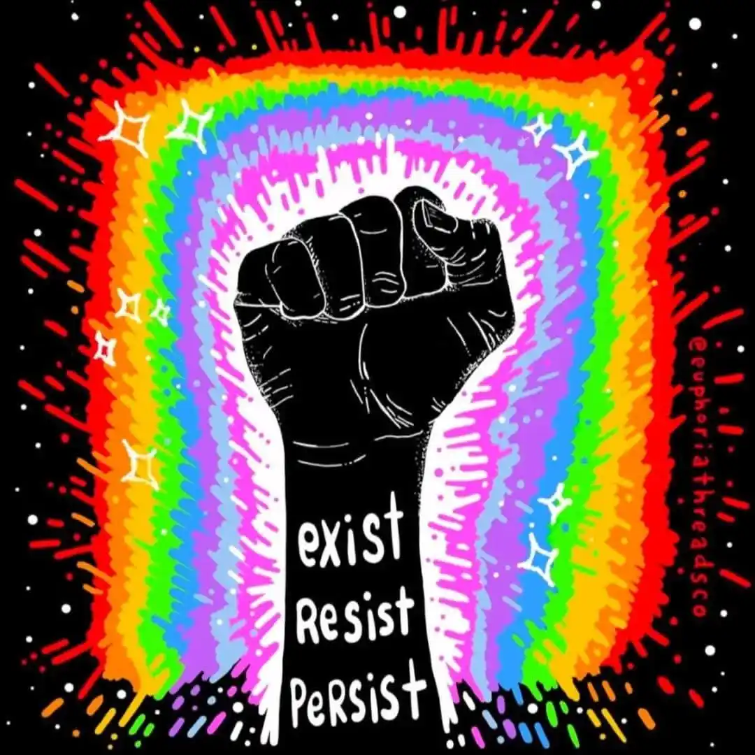 A stylized black fist is raised against a vibrant, multi-colored rainbow background with white sparkles and red streaks on a…