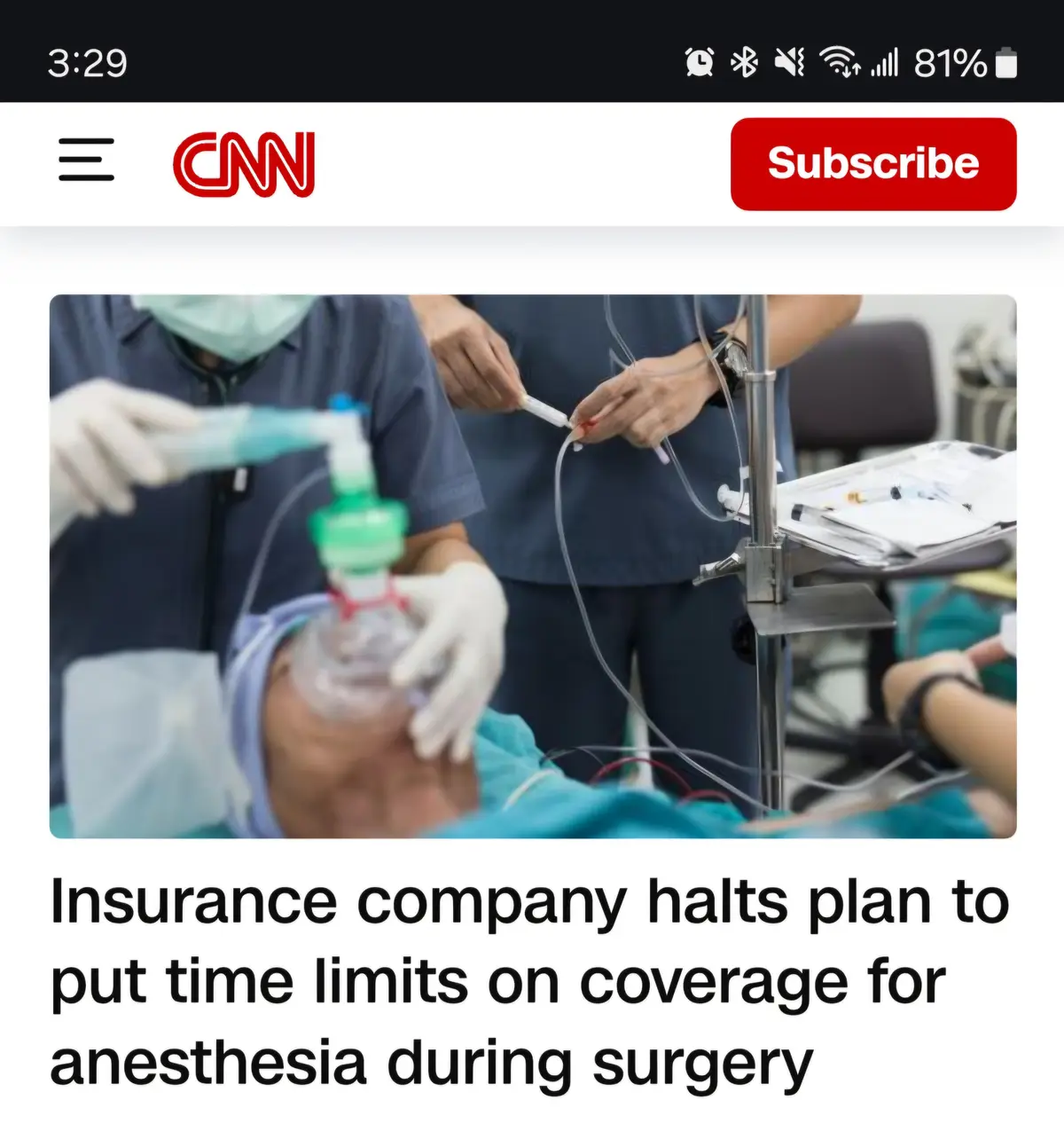 A screenshot of a CNN mobile news article shows a blurred image of a surgical scene with medical staff and equipment. The…