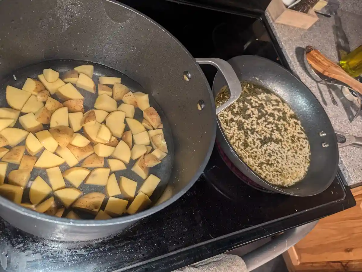 A kitchen scene shows two pots on a stovetop: one with chopped potatoes boiling in water, and another with oil and herbs…