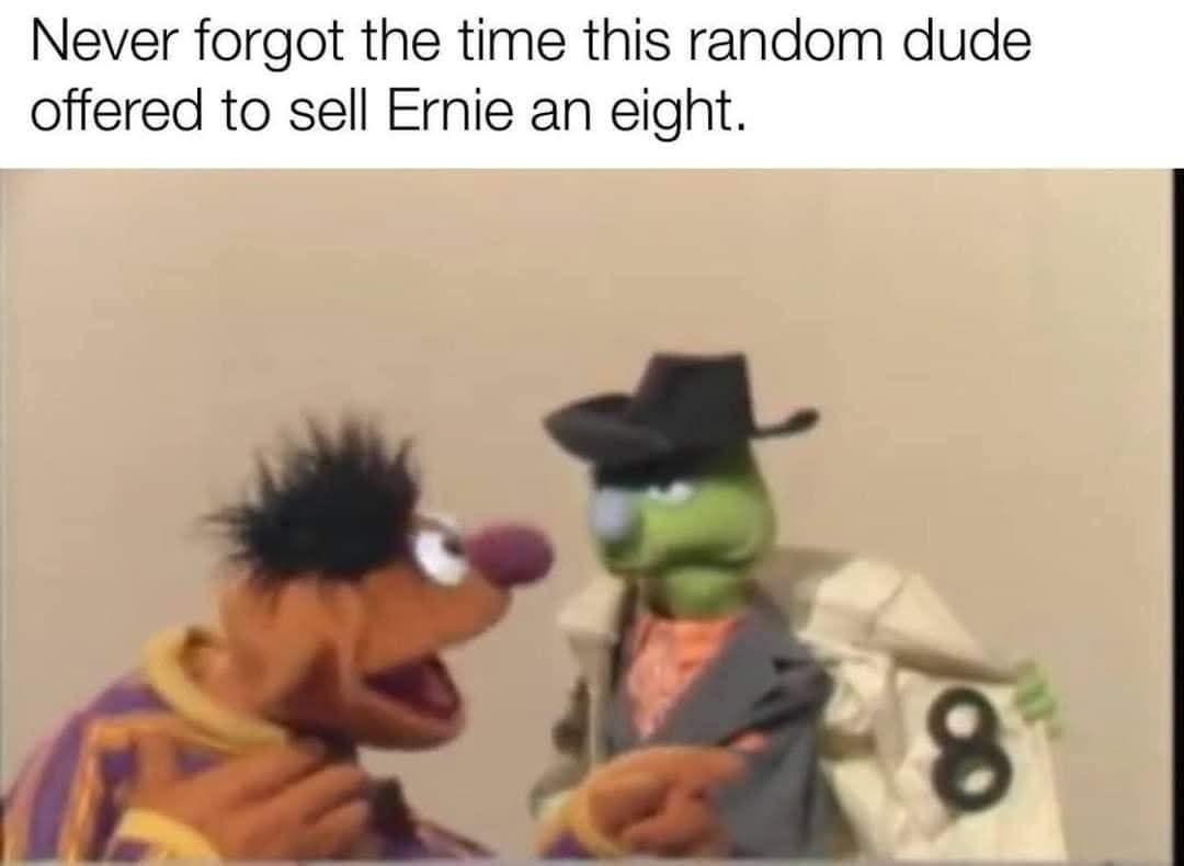The image shows two Muppet characters: Ernie, with spiky black hair and a purple shirt, looking surprised or excited, and a…