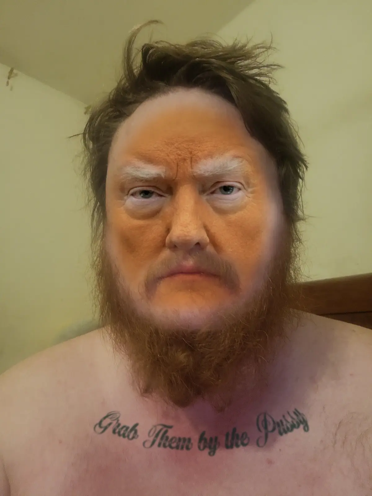 A shirtless man with a beard and messy hair has a digitally superimposed face resembling Donald Trump. The text 'Grab Them…