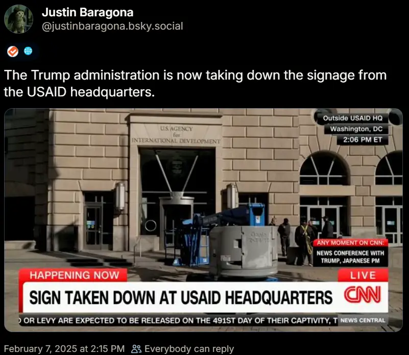 A screenshot of a CNN news broadcast shows workers removing a sign from the USAID headquarters building in Washington, DC…