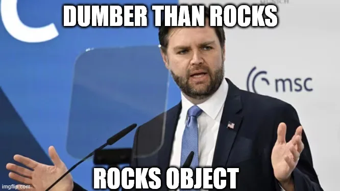 A man in a suit and tie stands at a podium with a serious, slightly confused expression, gesturing with both hands. The…